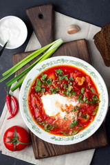 Traditional  ukrainian russian traditional beet red soup - borscht with sour cream on black stone background. Top view.