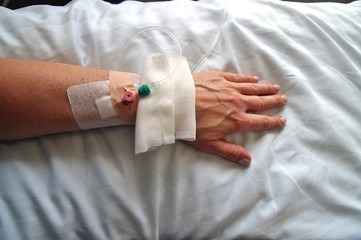 Female patient with infusion drip in hospital. arm of Woman, patient's hand, bottle of infusion in a hospital room during the Coronavirus COVID-19 disease epidemic, corona virus pandemic outbreak.