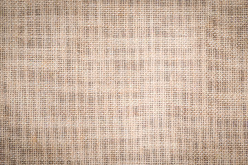 Fototapeta na wymiar Hessian sackcloth woven texture pattern background in tan sepia beige cream brown color