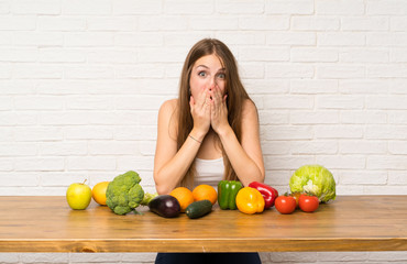 Young woman with many vegetables with surprise facial expression
