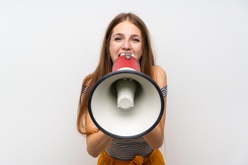 Young woman with long hair over isolated white wall shouting through a megaphone
