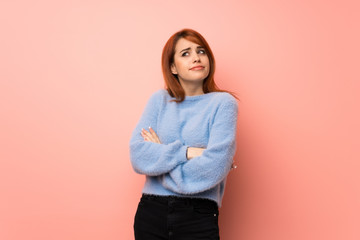 Young redhead woman over pink background making doubts gesture while lifting the shoulders