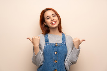 Young redhead woman over isolated background giving a thumbs up gesture with both hands and smiling