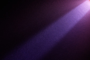 A bright beam of light shines from top to bottom on a darker background.