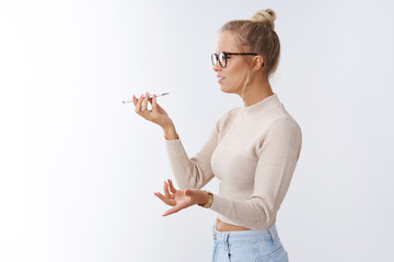 Woman arguing on phone talking via speaker holding smartphone near mouth spread hands in dismay...