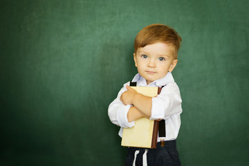 Knowledge is always yours. Cheerful smiling boy with books on a green background.