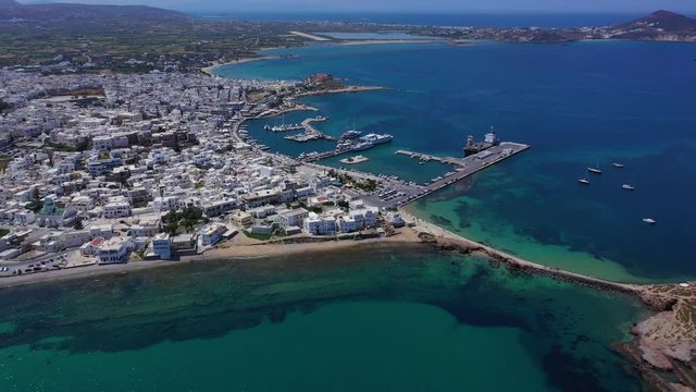 Aerial drone video of iconic chora, main town of Naxos island featuring beautiful uphill castle views to the Aegean deep blue sea and Temple of Apollon at the background, Cyclades, Greece