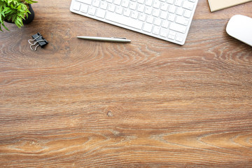 Wood office desk table with computer tools and supplies. Top view with copy space, flat lay.