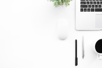 Modern white office desk table with laptop computer, cup of coffee and supplies. Top view with copy space, flat lay.