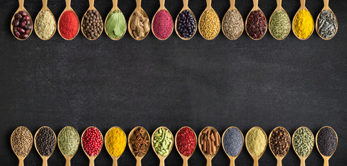 Spices and herbs in wooden spoons for website headers. Collection of spices with an empty space for an inscription or label. © dmitr1ch