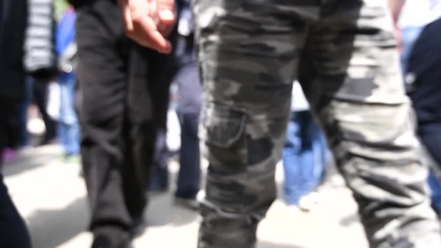 Low Angle View Of Street Crowd In Slow Motion, Group Of Unrecognizable People On Pavement From Lost Child Perspective