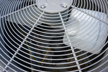 Residential air conditioning unit outdoors with fan and coils