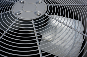 Residential air conditioning unit outdoors with fan and coils