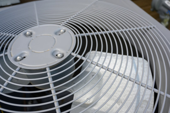 Residential air conditioning unit outdoors with fan and coils