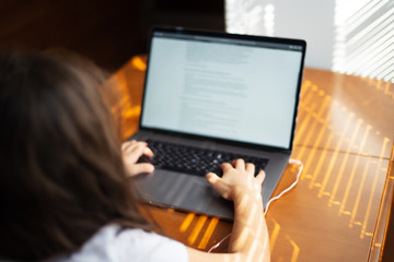 Children hands typing on keyboard of laptop