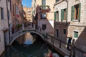 Footpath Bridge in a narrow Canal and the typical Venetian architecture. Venice, Italy