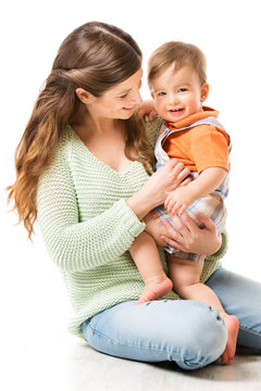 Mother and Baby, Happy Mom with Child one year old sitting on floor, Family Isolated over White background