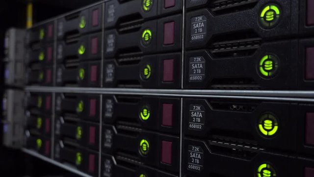 Storage racks with many hard drives in room of data center. HDD SATA. Side view.