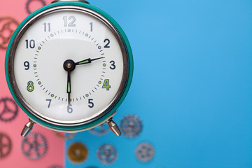 Retro alarm clock and small parts of watch on two colored background