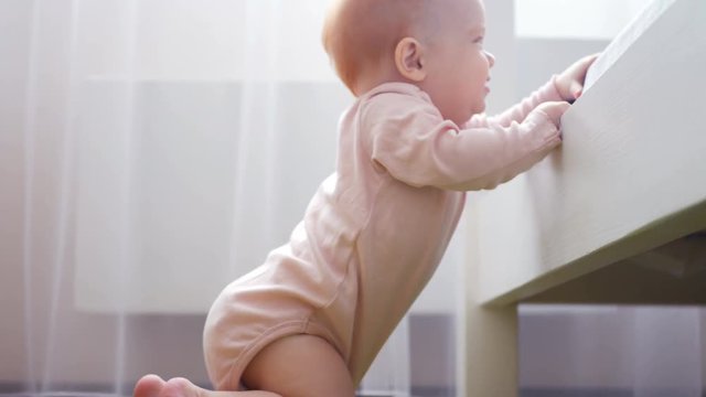 Readhead girl climbing to white sofa at home