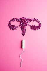 Tampon and ovary on pink background