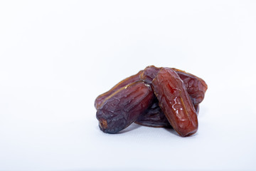 A group of medjool dates bottom right from Saudi Arabia on an isolated white background for Ramadan.