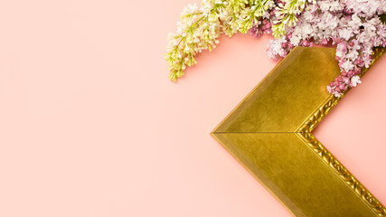 Corner of art frame with lilac flowers on pink background. Framing workshop concept.