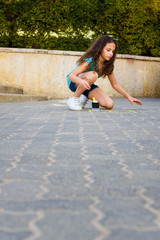 Adorable Curly Hair Girl drawing hopscotch with chalk on playground.
