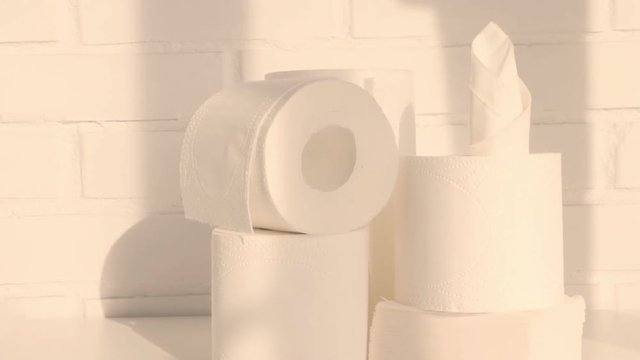 Paper towels, toilet paper and napkins in white loft interior. Paper disposables, hygienic products concept. Slow pan. Selective focus. Closeup.