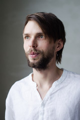Portrait of a young man in a white shirt with a beard