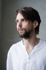 Obraz premium Portrait of a young man in a white shirt with a beard