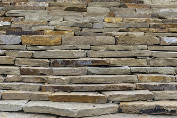 Construction of the wall of natural stone. Stone slabs stacked in a row on top of each other.
