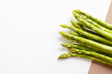Fresh green asparagus on a bright beautiful trendy background. Asparagus sprouts close up. Top view. Healthy and organic food. Raw products, fresh vegetables