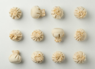 Composition with raw dumplings on white background, top view
