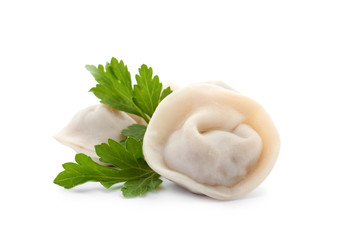 Boiled dumplings and parsley leaves on white background
