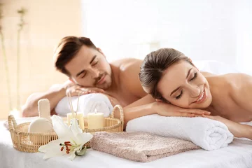 Poster Young couple with spa essentials in wellness center © New Africa