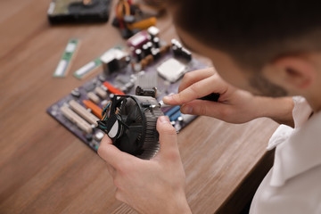 Naklejka premium Male technician repairing computer fan at table, closeup