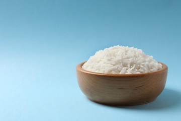 Bowl of tasty cooked rice on color background. Space for text