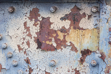 Background of rusted metal with peeling paint, nuts and bolts, copy space, horizontal aspect