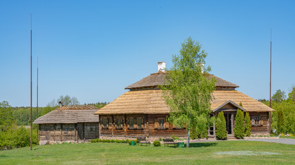 Old ancient wooden village house with green trees