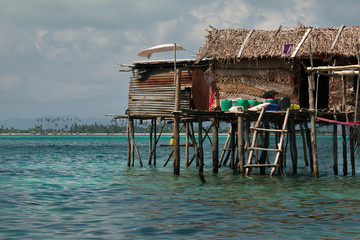East Malaysia. island of Borneo. Sea Gypsies relax after a night of fishing in a fishing village, whose huts are built on wooden stilts.