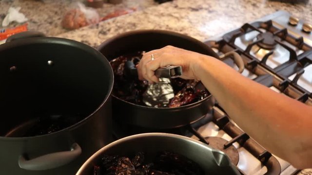 Top View. Woman taking out chile from the pot. Women making Mole in Puebla Mexico. North America.  Cooking Traditional recipe