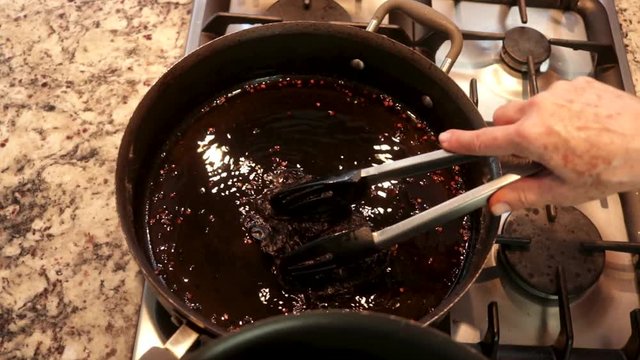Top View. Woman taking out Chile from the pot. Women making Mole in Puebla Mexico. North America.  Cooking Traditional recipe