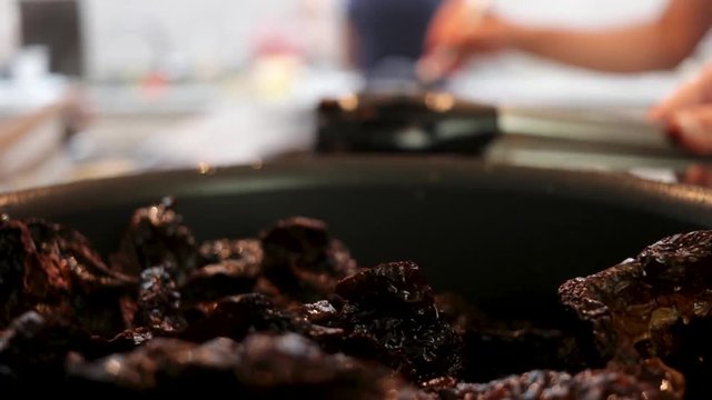 Side View. Close-up. Woman taking out chile from the pot. Women making Mole in Puebla Mexico. North America.  Cooking Traditional recipe