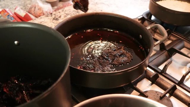 Top View. Close-up. Woman frying some chile in the pot.  Women making Mole in Puebla Mexico. North America.  Cooking Traditional recipe