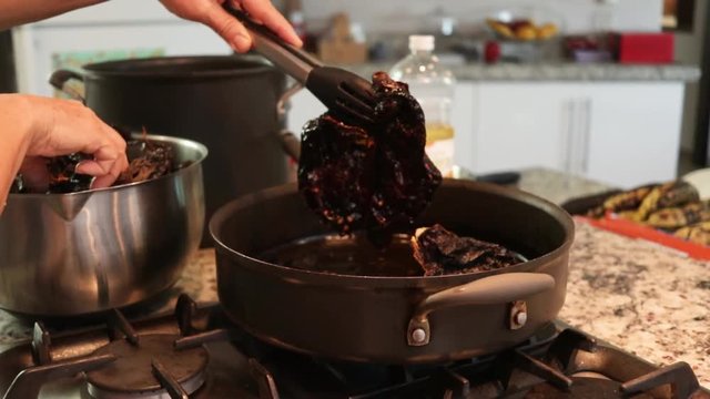 Side View. Woman frying some chile from the pot. Women making Mole in Puebla Mexico. North America.  Cooking Traditional recipe