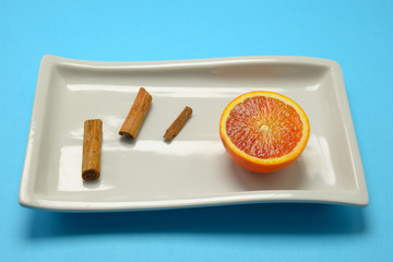 orange and cinnamon served in a white plate