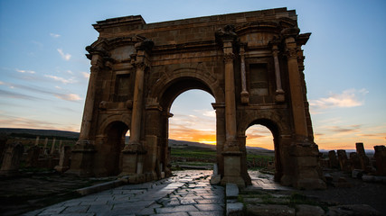 Fototapeta na wymiar Ancient Roman gate in Roman ruin under sunset