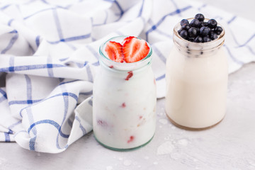 Jars of natural white yogurt decorated with fresh strawberry and mint. Healthy eating
