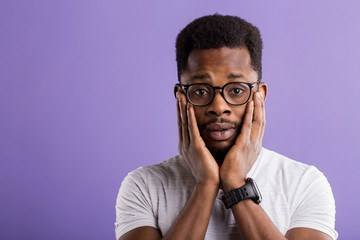Dark skinned man isolated over purple background
